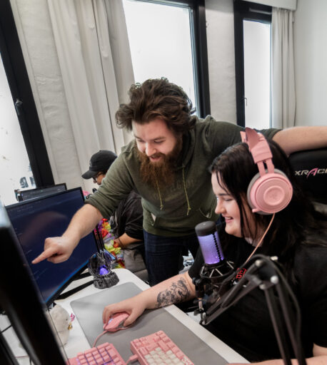 Lærer peker på skjerm og veileder student